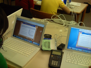 Picture of computers on a desk with a scientific calculator next to them.